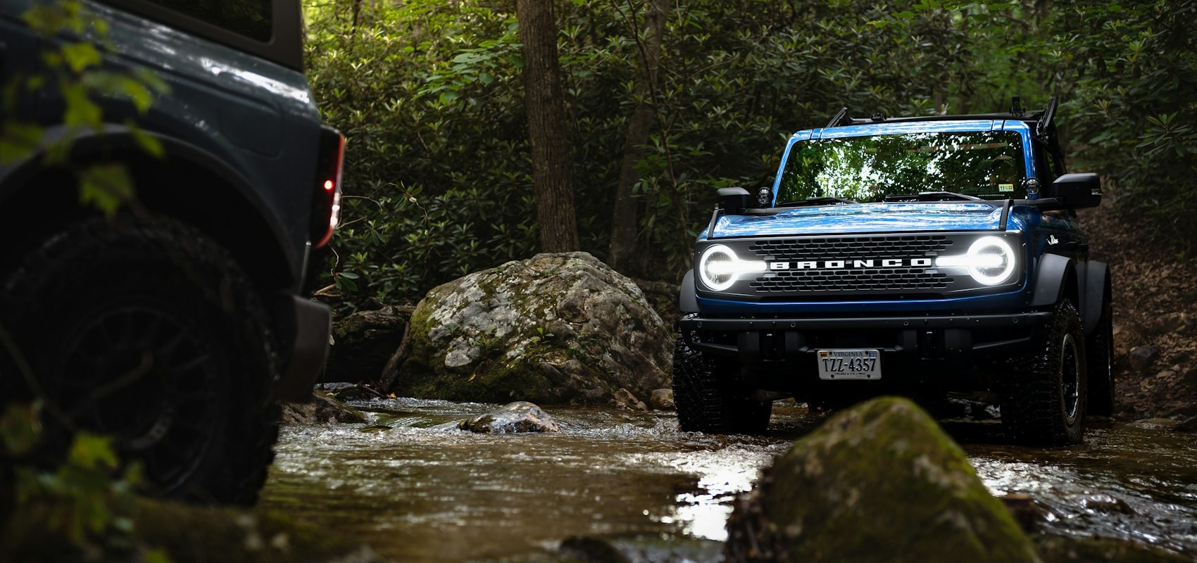 a car parked on pavement near a forest