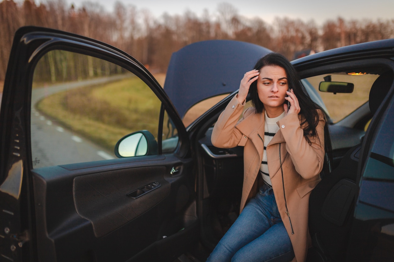 a woman sitting on the side mirror of a car